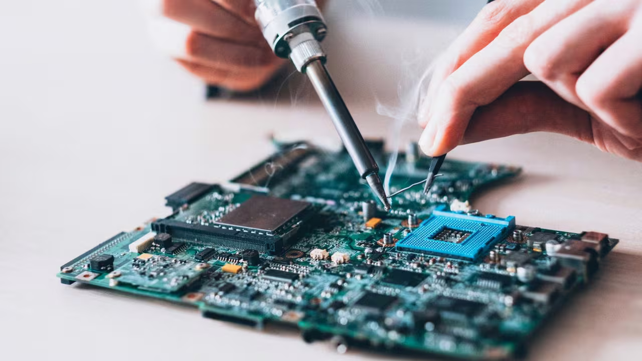 Two technicians working together at an organized laptop and desktop repair bench in Perumbakkam, Chennai